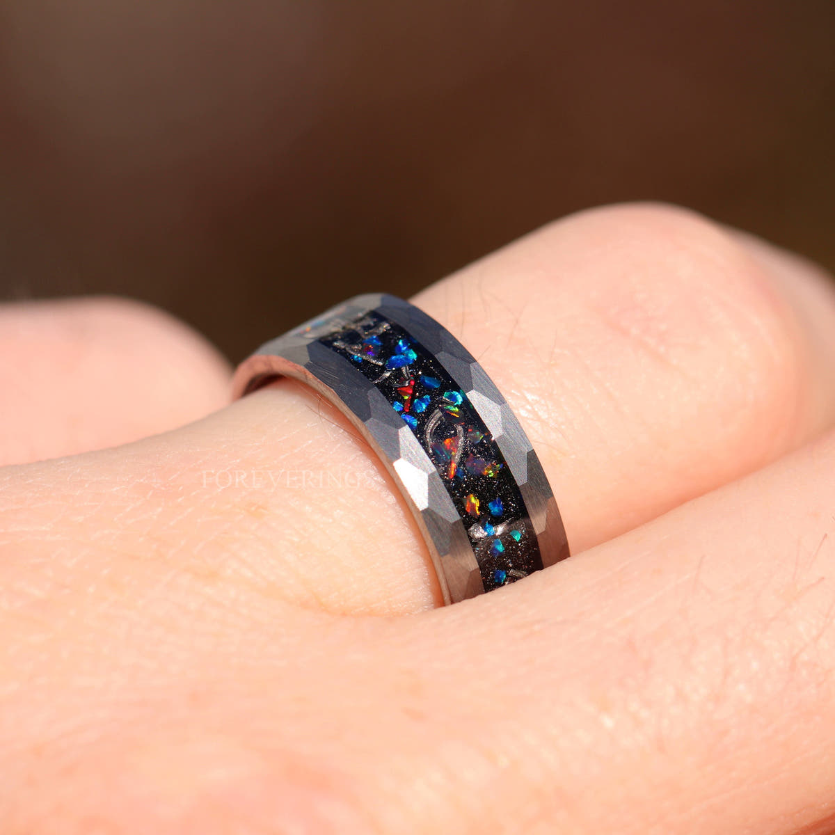 8mm meteorite and galaxy opal band on a finger, side view of the hammered silver edge