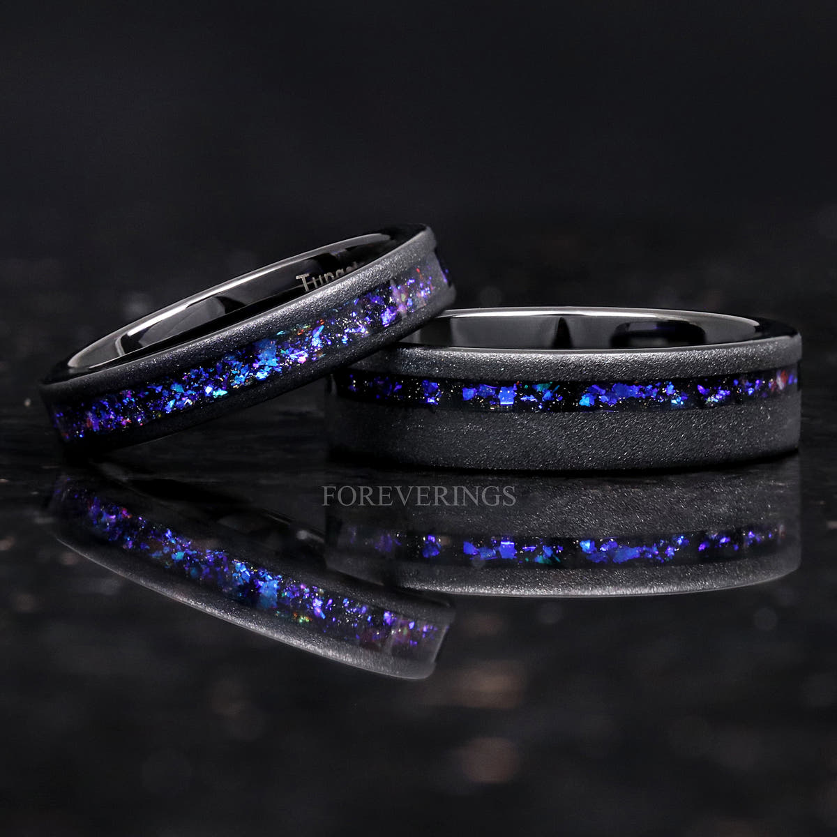 Black sandblasted tungsten nebula ring with a thinner nebula band leaning on it, wider view