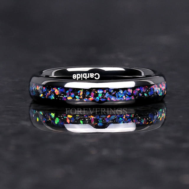 4mm black tungsten ring with blue opal inlay lying flat, reflection below