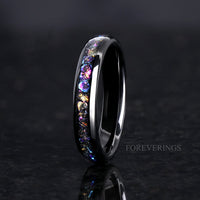 Women's 4mm black tungsten ring with iridescent moonstone inlay, standing on edge