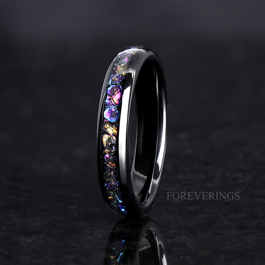 Women's 4mm black tungsten ring with iridescent moonstone inlay, standing on edge