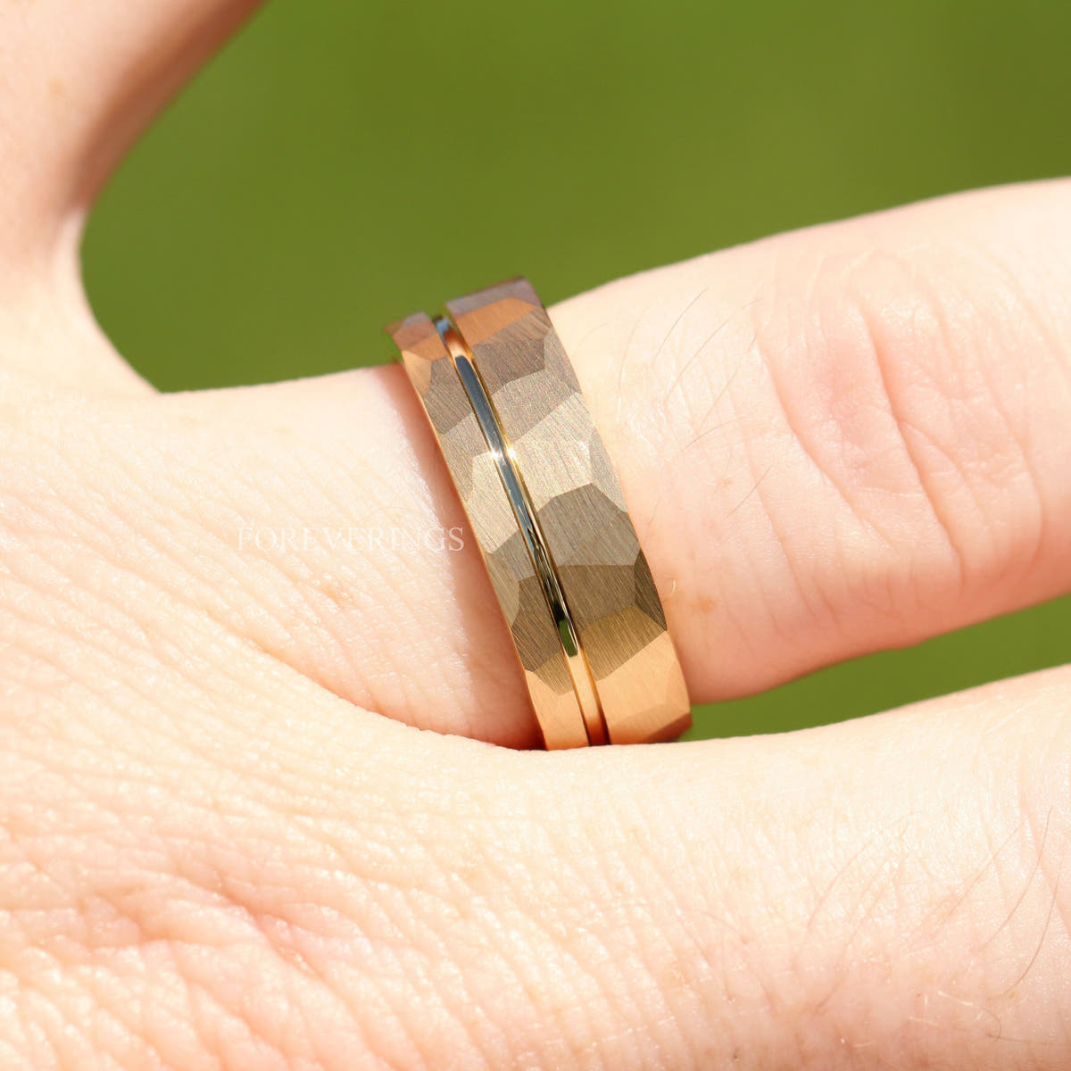 Close-up of the hammered gold band on a finger, offset groove across the facets