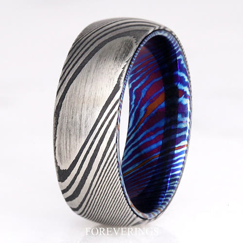 Men's 8mm Damascus steel wedding band with a blue Timascus lining, standing at an angle