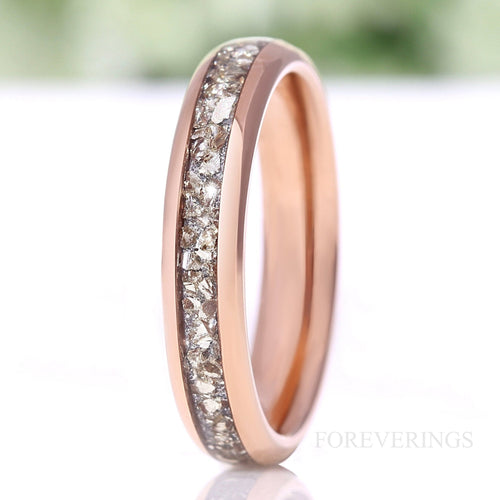 Women's 4mm rose gold tungsten wedding band with crushed diamond inlay, standing on edge