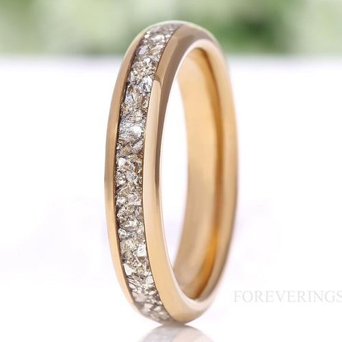 Women's 4mm gold tungsten wedding band with crushed diamond inlay, standing on edge