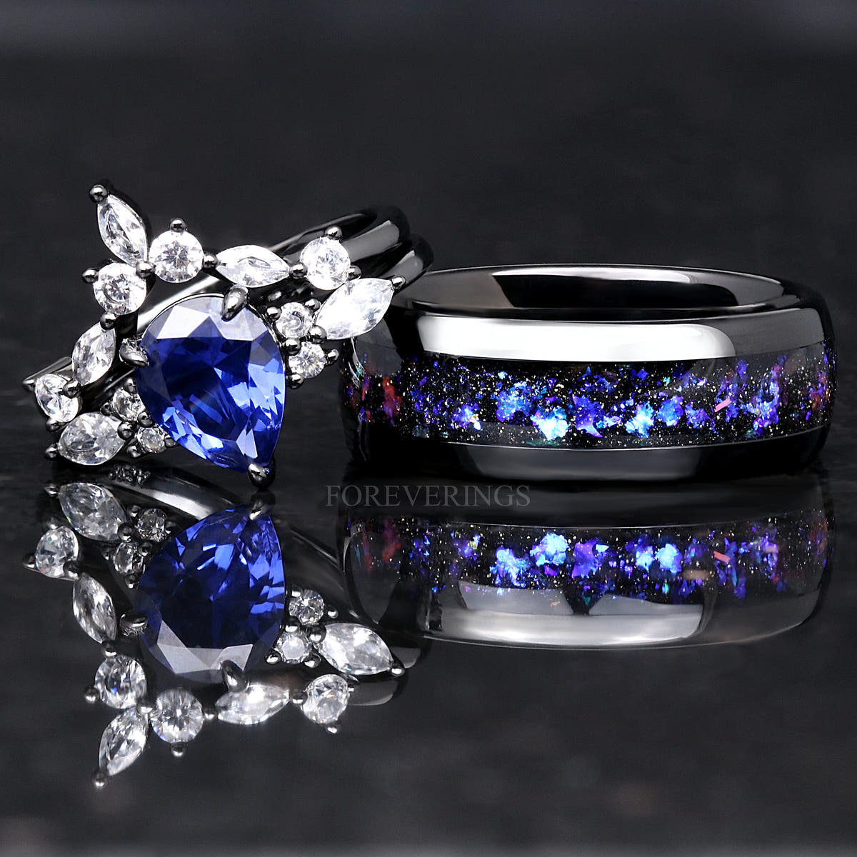 Black sterling silver blue sapphire bridal set beside a black men's band with a nebula inlay