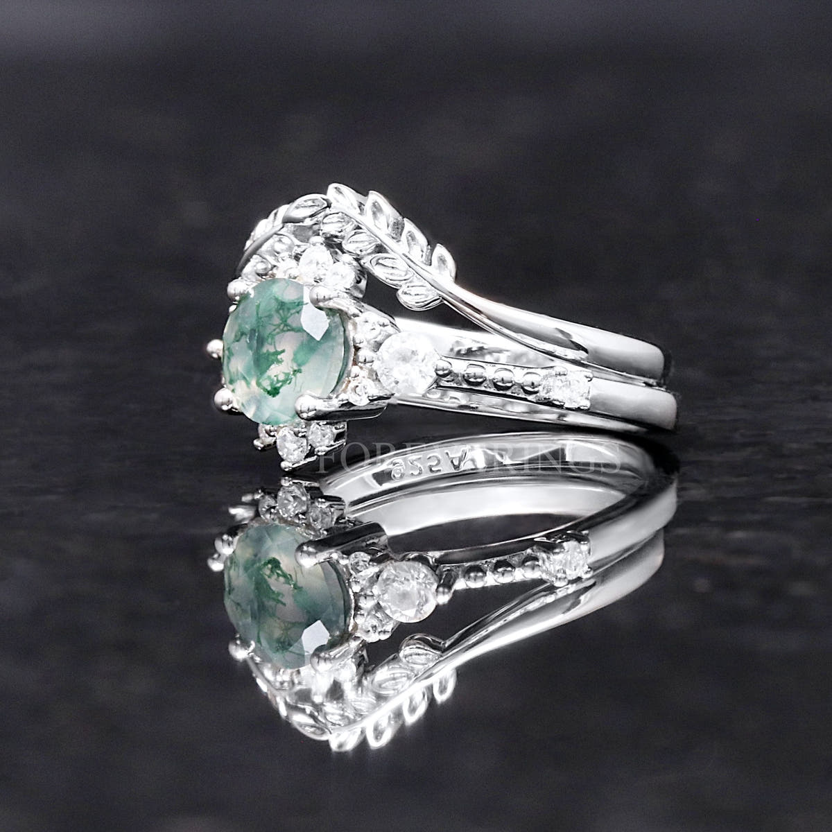Side view of the women's sterling silver moss agate ring and its accent band