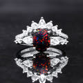 Women's sterling silver engagement ring with an oval black fire opal and a crown of clear stones, front view