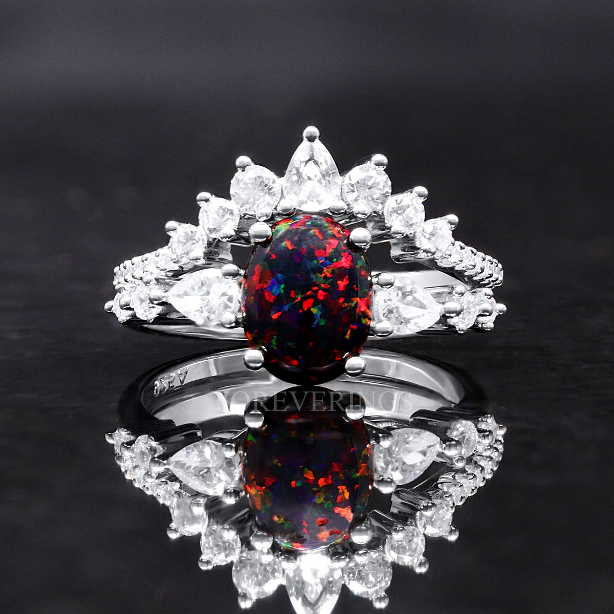 Women's sterling silver engagement ring with an oval black fire opal and a crown of clear stones, front view