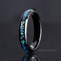 Women's 4mm black tungsten ring with blue opal and meteorite inlay, standing on edge
