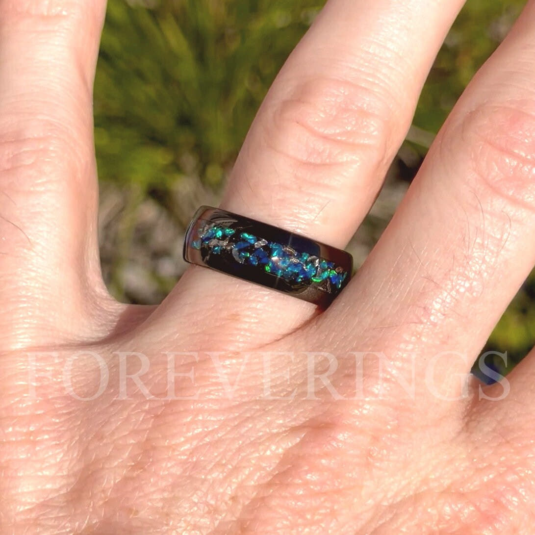 8mm black tungsten meteorite and blue opal band worn on a hand, close view