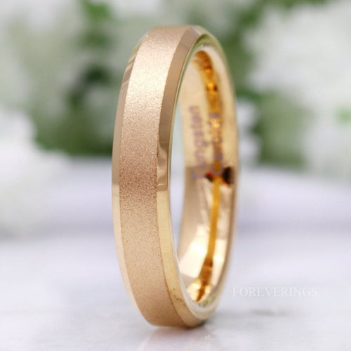 Women's 4mm sandblasted gold tungsten band with polished beveled edges, standing close up