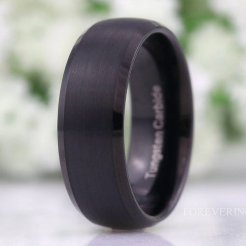 Men's 8mm matte black tungsten wedding band with beveled edges, standing at an angle