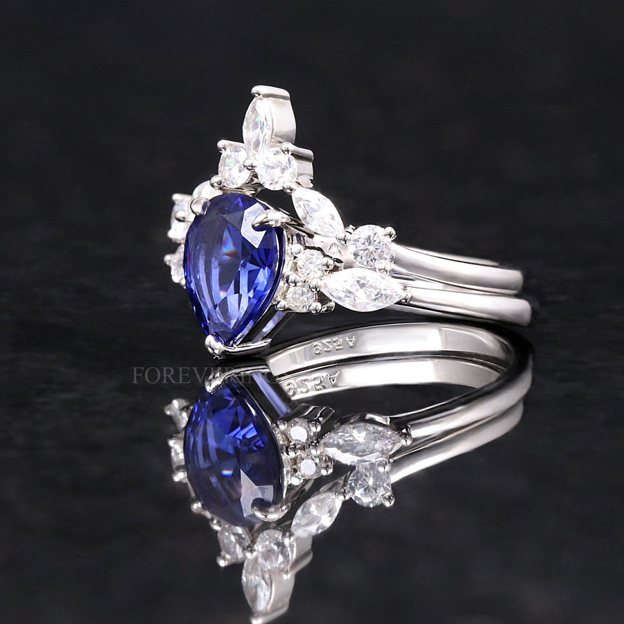 Pear-cut sapphire engagement ring and nesting band in sterling silver, angled side view