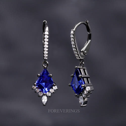 Women's Orion Nebula drop earrings in black sterling silver with kite cut blue sapphires, one turned sideways
