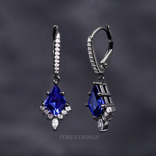 Women's Orion Nebula drop earrings in black sterling silver with kite cut blue sapphires, one turned sideways