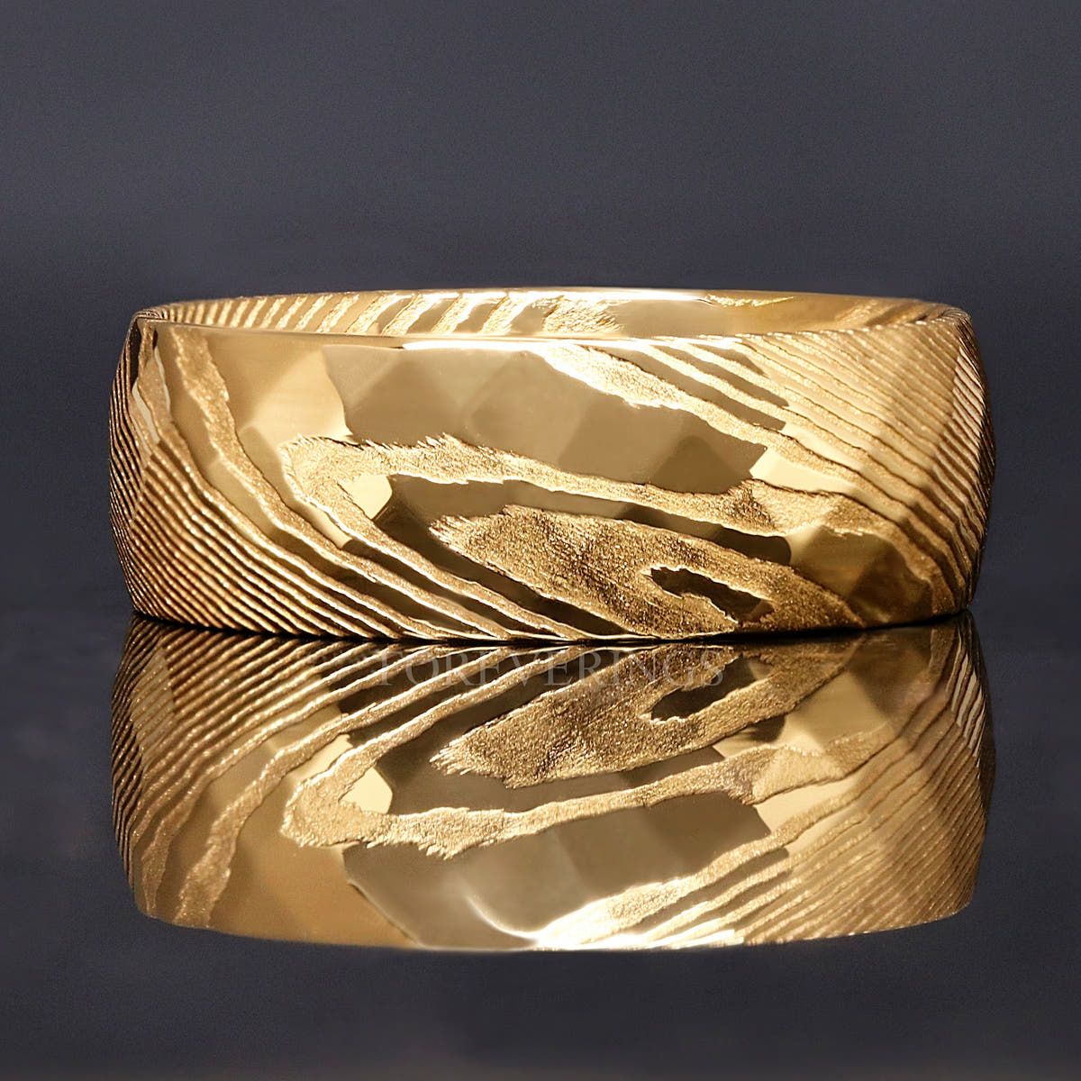 Side view of the gold Damascus steel band showing the swirled steel pattern and facets