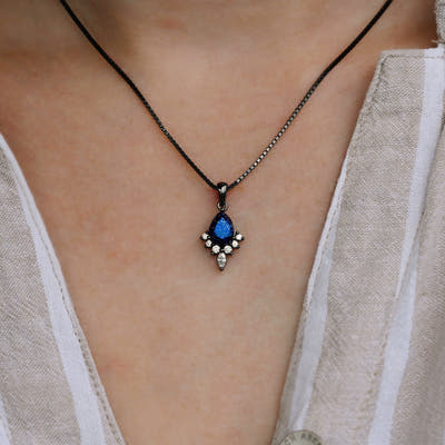 Pear blue sandstone pendant necklace worn at the neck, close crop