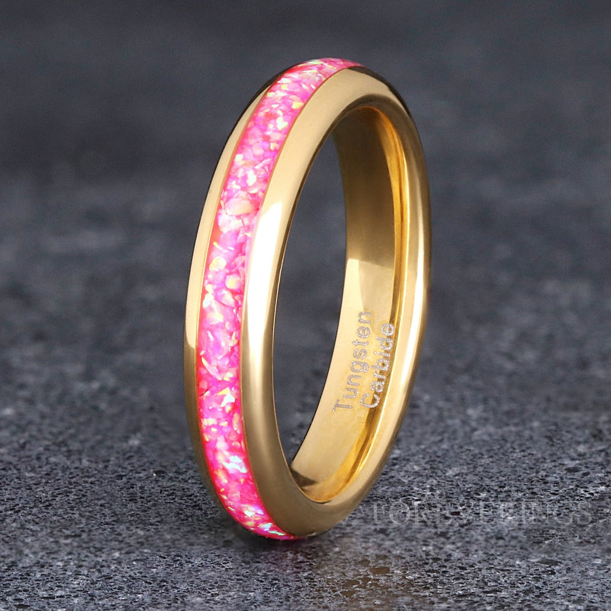 Women's 4mm gold tungsten band with pink fire opal inlay, standing at an angle