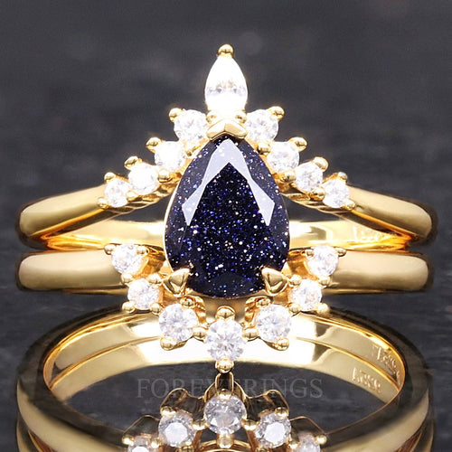 Gold sterling silver bridal set with a pear-cut blue sandstone center and curved band, straight on