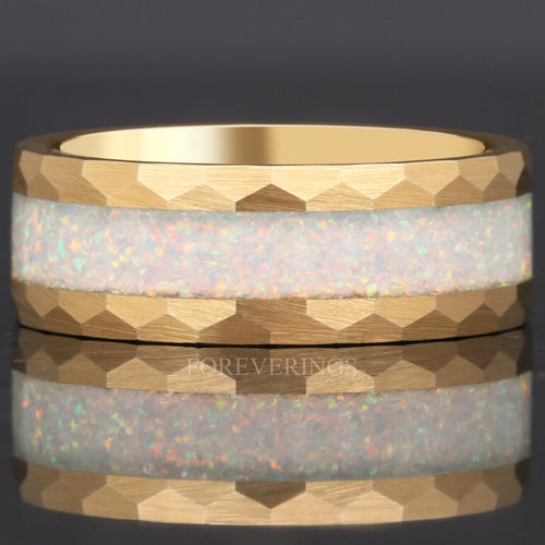 8mm hammered gold tungsten ring with white fire opal inlay lying flat, seen straight on, close crop