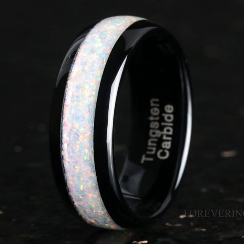 Men's 8mm black tungsten wedding ring with white fire opal inlay, standing at an angle