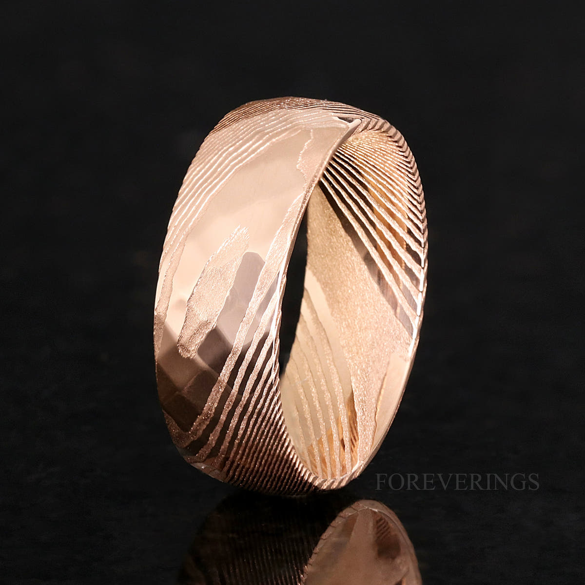 8mm rose gold Damascus steel ring standing on edge, showing the wavy Damascus pattern