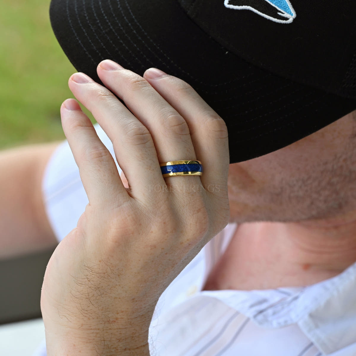 Gold tungsten lapis lazuli wedding band worn on a man's hand