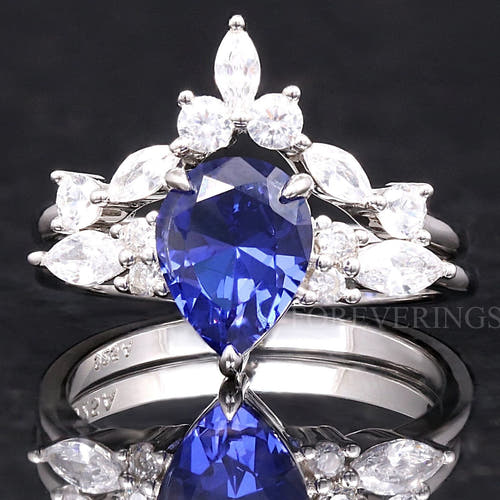 Women's sterling silver bridal set with a pear-cut sapphire and a curved marquise accent band, front view