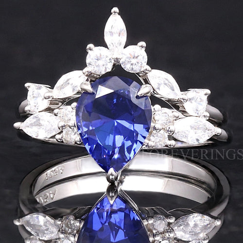Women's sterling silver bridal set with a pear-cut sapphire and a curved marquise accent band, front view