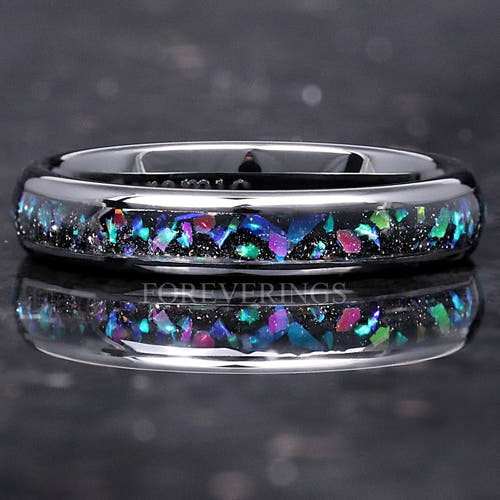 4mm black ceramic ring with galaxy opal inlay lying flat, seen straight on with reflection below