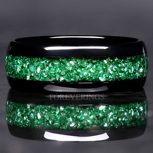 Black tungsten wedding band with crushed emerald inlay, close front view with reflection