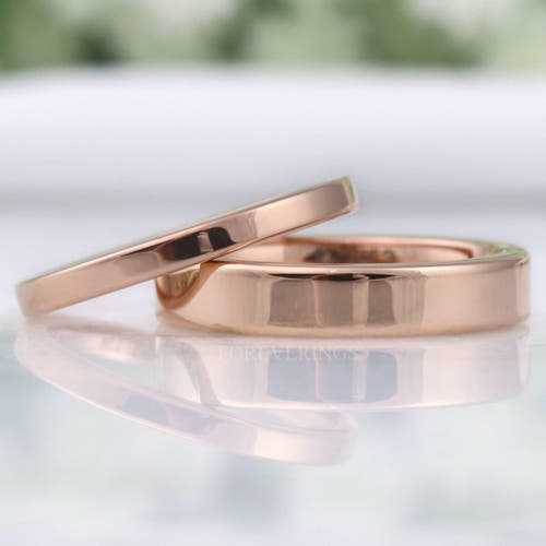 Flat rose gold tungsten wedding bands in 2mm and 4mm, polished, leaning together