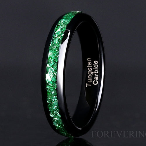 4mm black tungsten wedding band with a crushed emerald stone inlay, standing at an angle