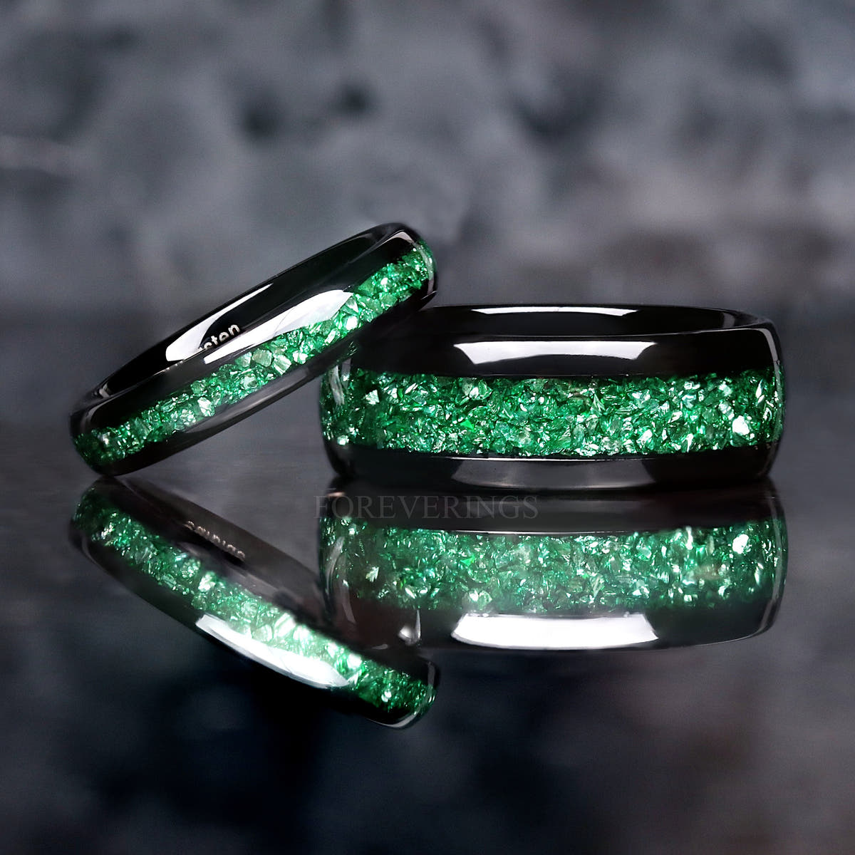 4mm emerald inlay band leaning on a wider black tungsten emerald band
