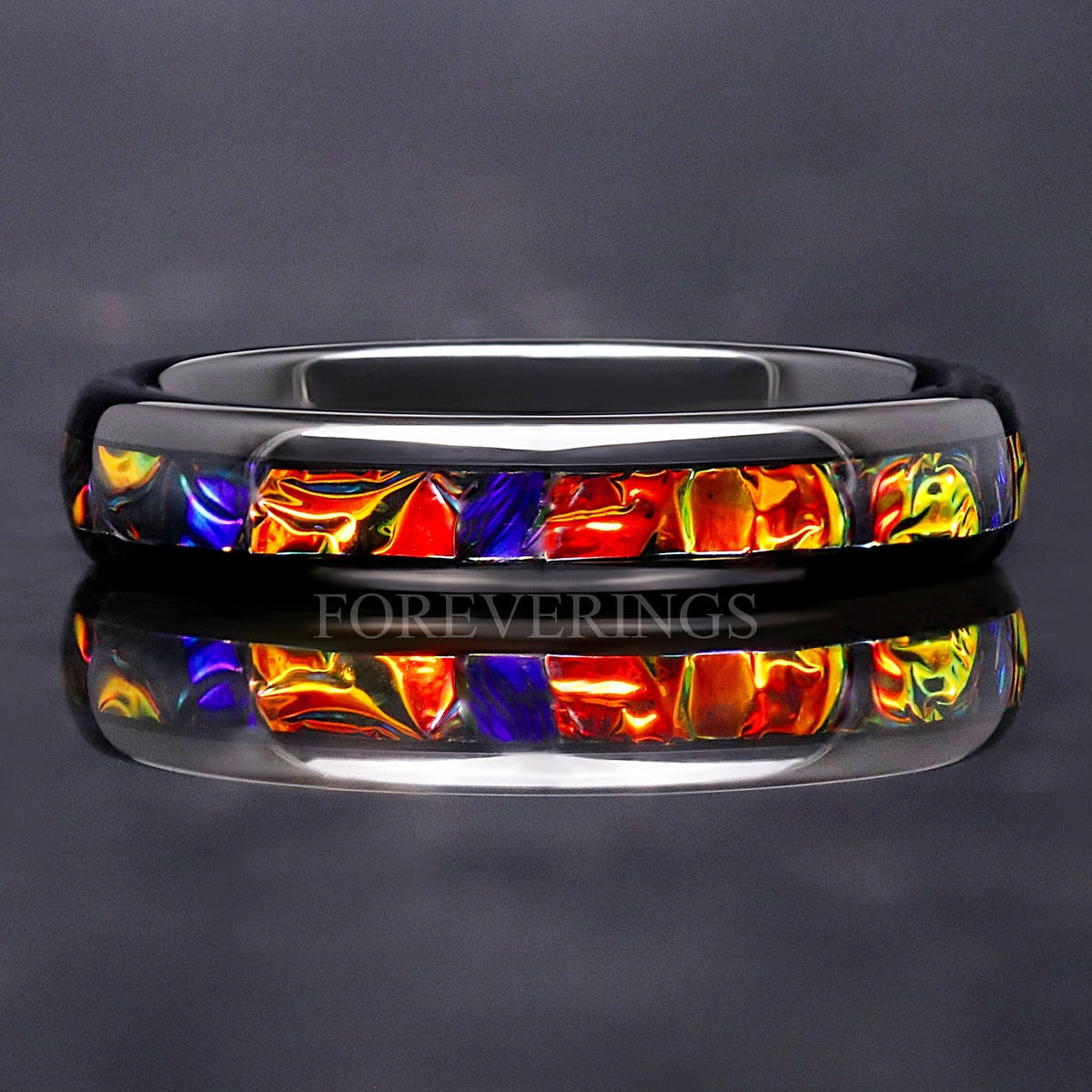 4mm black tungsten band with red, orange and blue dichrolam inlay, straight on in a close crop