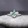 Women's sterling silver kite-cut moss agate ring with a twirl scroll band, shown straight on