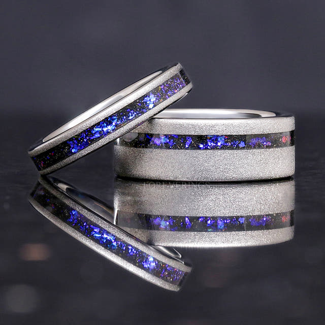 4mm silver nebula ring leaning on a wider sandblasted silver band with nebula inlay