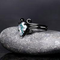 Women's black sterling silver kite cut moss agate ring with swirl details, angled side view