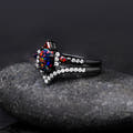 Angled side view of the black fire opal engagement ring and curved band with white stones