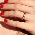 Women's 4mm rose gold tungsten ring with white fire opal inlay worn on a hand