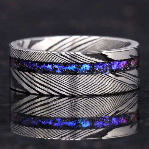 Men's 8mm Damascus steel band with an offset Orion Nebula sandstone stripe, lying flat