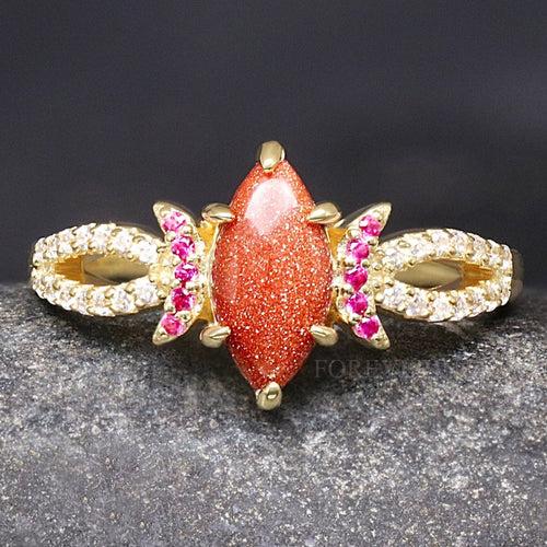 Women's gold sterling silver ring with a marquise red sandstone and ruby crescent moons, close front view