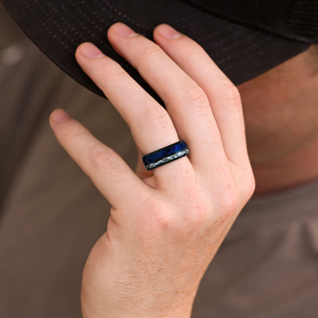 Men's 8mm black tungsten band with blue sandstone and crushed diamond inlay worn on a hand