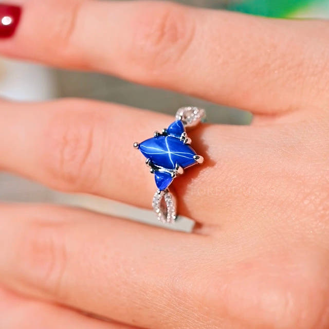 Vintage-style sterling silver star sapphire engagement ring worn on a finger