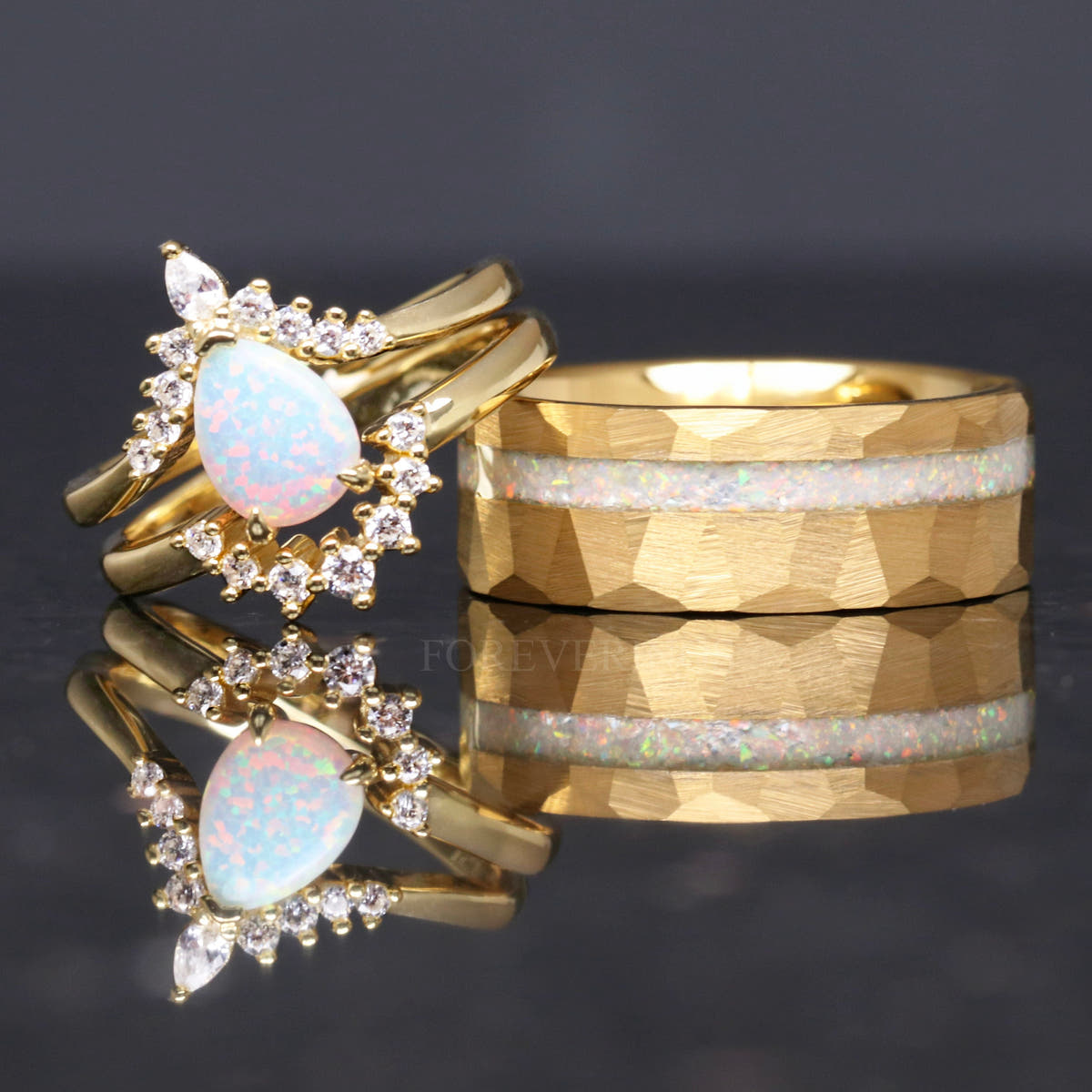 Gold opal bridal set leaning on a wide hammered gold band with white opal inlay
