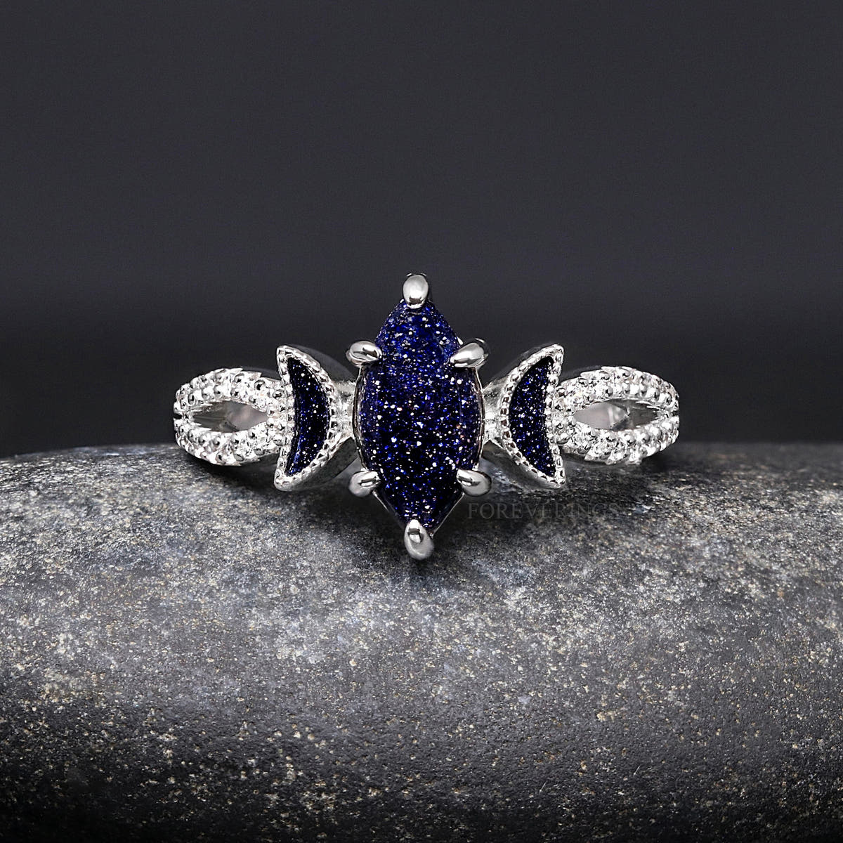 Sterling silver crescent moon ring with a marquise blue sandstone, shown straight on
