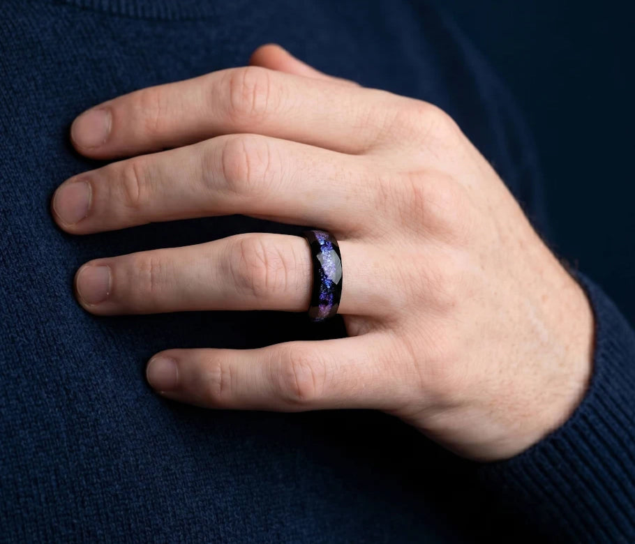 Black wedding band with a purple inlay, worn on a hand