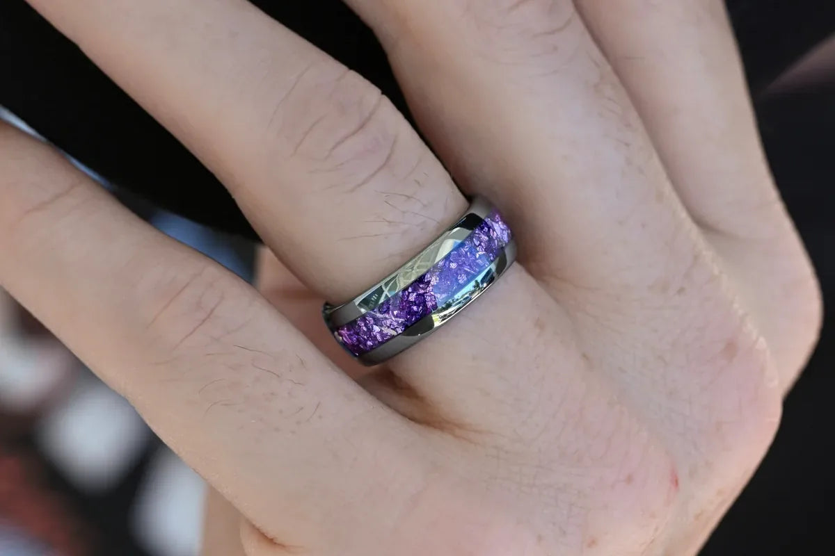 Mens silver tungsten wedding band with purple crushed stone inlay worn on his hand