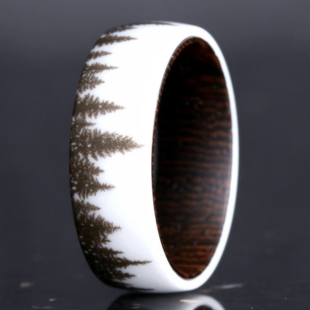 Men's white ceramic wedding band with a forest tree-line design and dark wood interior